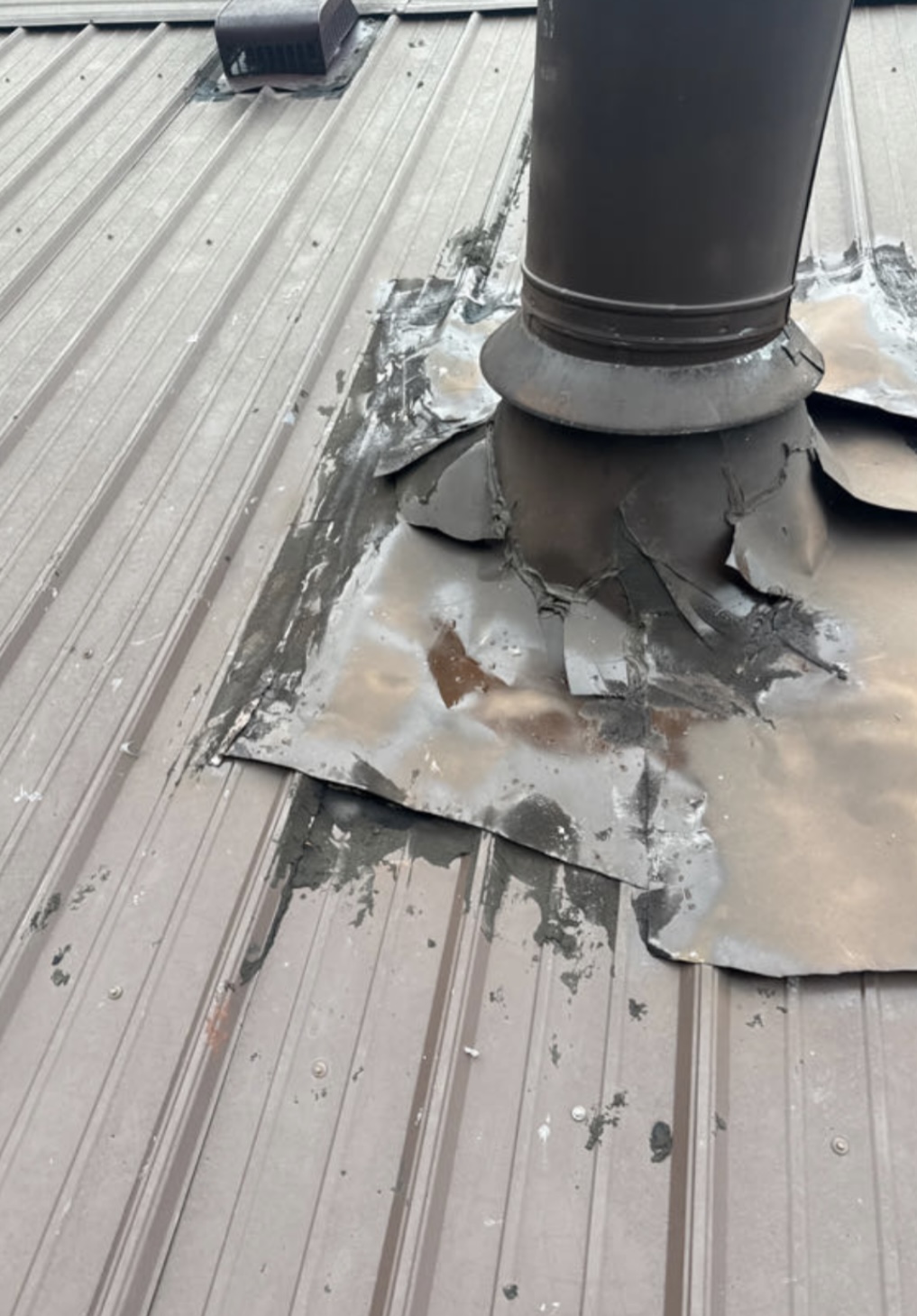 Failing pipe boot sealed with tar